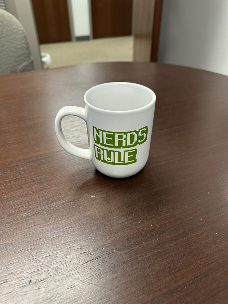 A coffee mug that says "Nerds Rule"